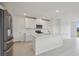 Bright kitchen features stainless steel refrigerator and island with sink and dishwasher at 3634 Moscato Dr, Brooksville, FL 34602