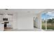 Bright living room featuring white walls, a modern kitchen, and sliding glass doors to the outside at 3634 Moscato Dr, Brooksville, FL 34602