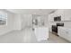 Open-concept living room featuring a modern kitchen with white cabinets and a kitchen island at 3634 Moscato Dr, Brooksville, FL 34602