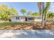 Charming single-story home with a red front door and a well-maintained lawn, located near lush trees at 777 27Th S Ave, St Petersburg, FL 33705