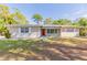 Inviting single-story home with a classic design, featuring a red front door and mature landscaping at 777 27Th S Ave, St Petersburg, FL 33705