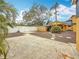 Expansive backyard with gravel, concrete patio and walkway, featuring a white fence and mature trees at 8135 33Rd Ave N, St Petersburg, FL 33710