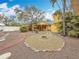 Backyard featuring a fire pit, mature trees, gravel, and a covered porch at 8135 33Rd Ave N, St Petersburg, FL 33710
