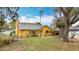Charming yellow home featuring a metal roof, well-manicured lawn, and beautiful landscaping at 8135 33Rd Ave N, St Petersburg, FL 33710