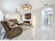 Spacious living room with white tile floor, fan and sectional couch; great for relaxation at 8135 33Rd Ave N, St Petersburg, FL 33710