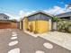 A yellow storage shed with a metal roof and potted cactus in a modern, well kept backyard at 8135 33Rd Ave N, St Petersburg, FL 33710