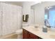 Bathroom with a combination shower and tub, single sink vanity with cherry wood cabinets, and a large mirror at 8539 Sandpiper Ridge Ave, Tampa, FL 33647