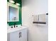 Stylish bathroom with a green accent wall, white vanity, and modern fixtures at 8539 Sandpiper Ridge Ave, Tampa, FL 33647