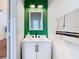 Contemporary bathroom with a green accent wall, white vanity, and updated lighting at 8539 Sandpiper Ridge Ave, Tampa, FL 33647