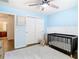 Comfortable Bedroom featuring a modern crib, neutral decor, plush rug, and bright, cheerful blue walls at 8539 Sandpiper Ridge Ave, Tampa, FL 33647