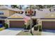 Charming yellow townhome with two-car garage, an American flag, and tidy landscaping at 8539 Sandpiper Ridge Ave, Tampa, FL 33647
