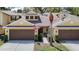 Townhome exterior features a two-car garage and a well-maintained lawn with an American flag at 8539 Sandpiper Ridge Ave, Tampa, FL 33647