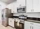 Modern kitchen with stainless steel appliances, white cabinets, and dark countertops at 8539 Sandpiper Ridge Ave, Tampa, FL 33647