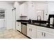 Modern kitchen featuring white cabinets, stainless steel appliances, and a barn door to the laundry at 8539 Sandpiper Ridge Ave, Tampa, FL 33647