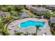 Aerial view of community pool with ample seating, nearby pond, and lush landscaping at 8539 Sandpiper Ridge Ave, Tampa, FL 33647