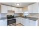 Bright kitchen with white cabinets, granite countertops, and stainless steel appliances at 10151 114Th N Ter, Largo, FL 33773
