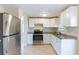Modern kitchen featuring white cabinets, stainless steel appliances, and granite countertops at 10151 114Th N Ter, Largo, FL 33773