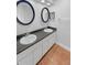 Bathroom with double sinks, vanity, two round mirrors, and neutral decor with a tile floor at 110 Lakeside Colony Dr, Tarpon Springs, FL 34689