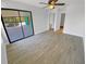 A spacious bedroom featuring wood-look tile flooring and sliding door access to balcony at 110 Lakeside Colony Dr, Tarpon Springs, FL 34689