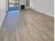 An open living room featuring wood-look tile flooring and sliding doors to the exterior at 110 Lakeside Colony Dr, Tarpon Springs, FL 34689