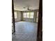 Partially renovated living area with new flooring, large windows, and ceiling fan at 1810 New Hampshire Ne Ave, St Petersburg, FL 33703