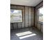 Sunlit room with new flooring, two windows, and exposed concrete block walls at 1810 New Hampshire Ne Ave, St Petersburg, FL 33703