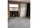 Partially renovated room featuring new flooring, a window, and a white door at 1810 New Hampshire Ne Ave, St Petersburg, FL 33703