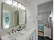 Bright bathroom with a double vanity, tile backsplash, and doorway access to a connected bedroom at 18526 Sweetbay Ln, Dade City, FL 33523