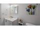 Well-lit bathroom with a clean, white vanity and a decorative floral arrangement at 18526 Sweetbay Ln, Dade City, FL 33523