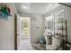 Bright bathroom featuring tiled floors, a pedestal sink, and a window providing natural light at 18526 Sweetbay Ln, Dade City, FL 33523