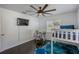 Bright bedroom features a ceiling fan, dark hardwood floors, a TV, a window and a desk area at 18526 Sweetbay Ln, Dade City, FL 33523