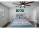 This bright bedroom has a ceiling fan, hardwood floors, a full bed, and access to the bathroom at 18526 Sweetbay Ln, Dade City, FL 33523