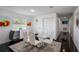 Dining room with glass table, seating for six and modern art on the walls at 18526 Sweetbay Ln, Dade City, FL 33523
