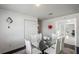Dining area with a glass table and white chairs, illuminated by natural light at 18526 Sweetbay Ln, Dade City, FL 33523