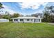 Attractive home with a white exterior, metal roof and well-manicured lawn at 18526 Sweetbay Ln, Dade City, FL 33523