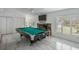 Well-lit game room boasts a pool table, TV, fireplace and view to the pool at 18526 Sweetbay Ln, Dade City, FL 33523