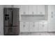 Kitchen features stainless steel refrigerator, white cabinets, and modern backsplash at 18526 Sweetbay Ln, Dade City, FL 33523