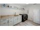 Well-organized laundry room with modern washer and dryer, ample storage, and stylish countertops at 18526 Sweetbay Ln, Dade City, FL 33523
