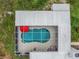 Overhead view of a screened pool with unique shape and an outdoor umbrella at 18526 Sweetbay Ln, Dade City, FL 33523