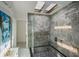 This sleek tiled shower features a frameless glass door and a skylight for natural light at 18526 Sweetbay Ln, Dade City, FL 33523