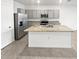 Modern kitchen featuring gray cabinets, granite countertops, stainless steel appliances, and a center island with a sink at 2921 Flowering Moss Run, Wesley Chapel, FL 33543