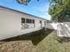 A view of the backyard, showing the white fence, white exterior wall and blue sky at 2052 Sheffield Ct, Oldsmar, FL 34677