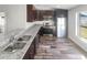 Modern kitchen featuring stainless steel appliances, dark wood cabinets, granite countertops, and hardwood floors at 2052 Sheffield Ct, Oldsmar, FL 34677