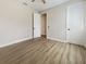 Bedroom with wood-look floors and an open doorway leading to the hallway at 11443 Apple Tree Cir, Bradenton, FL 34211