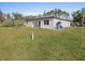 The backyard features a lush lawn and the home's exterior at 24299 Kingsway Cir, Punta Gorda, FL 33983