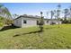 The backyard features a lush lawn and the home's exterior at 24299 Kingsway Cir, Punta Gorda, FL 33983