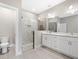 Modern bathroom boasts double vanity, glass enclosed shower, and contemporary lighting fixtures at 24299 Kingsway Cir, Punta Gorda, FL 33983