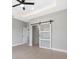 Bedroom with recessed lighting, ceiling fan, en suite bathroom, and a sliding barn door at 24299 Kingsway Cir, Punta Gorda, FL 33983