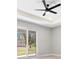 Bedroom featuring tray ceilings, fan, and sliding glass doors leading to the backyard at 24299 Kingsway Cir, Punta Gorda, FL 33983