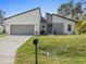 Well-manicured lawn enhances the curb appeal of this modern, one-story home with a two-car garage at 24299 Kingsway Cir, Punta Gorda, FL 33983